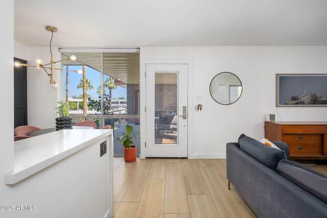 1225 E Medlock Dr Unit 206, Phoenix, AZ 85014 - living room with light wood finished floors, a chandelier, and baseboards