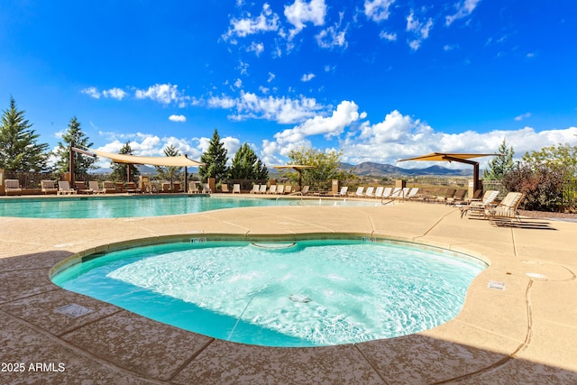 community pool featuring a mountain view and a patio area