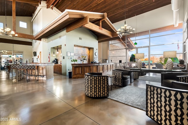 living room featuring finished concrete flooring, a towering ceiling, wood ceiling, and an inviting chandelier