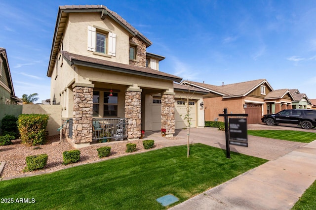 view of front facade with covered porch, stone siding, driveway, stucco siding, and a front lawn