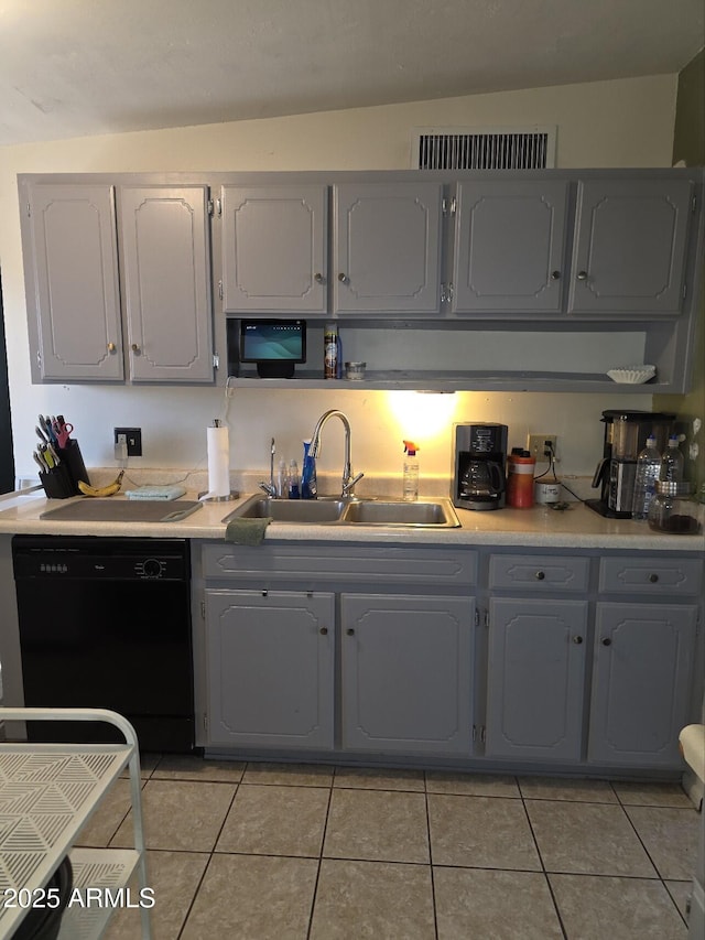 kitchen with light tile patterned flooring, gray cabinets, a sink, light countertops, and dishwasher