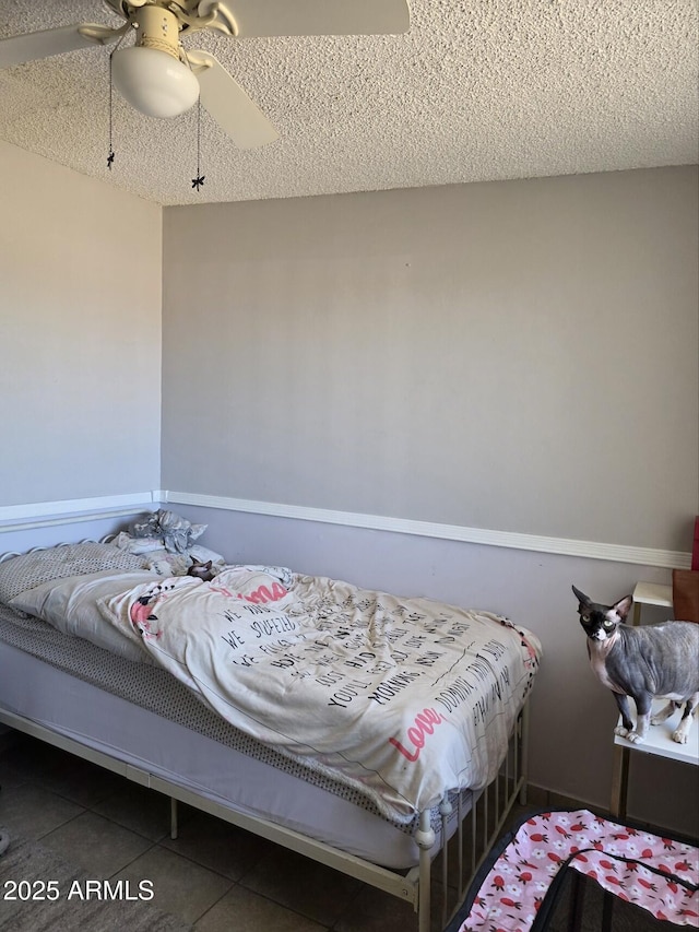 tiled bedroom with a textured ceiling and a ceiling fan