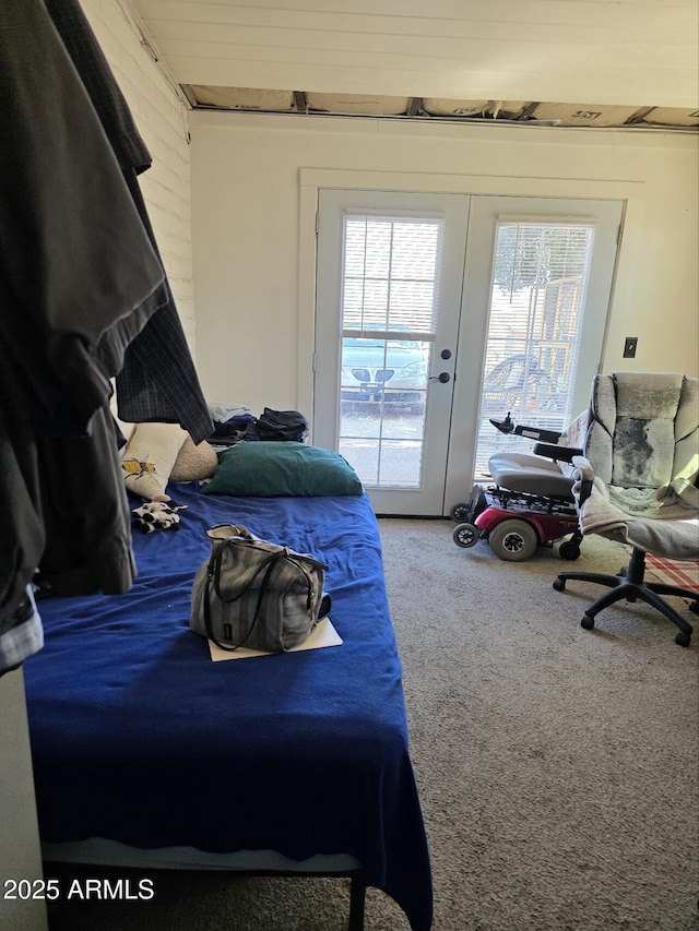 carpeted bedroom with access to outside, multiple windows, and french doors