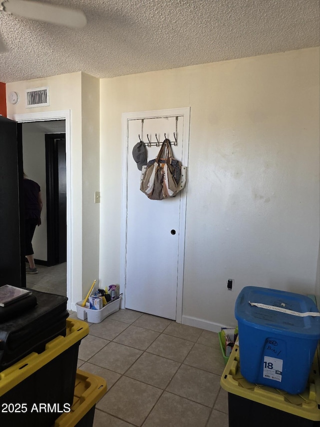 interior space with baseboards, visible vents, and a textured ceiling