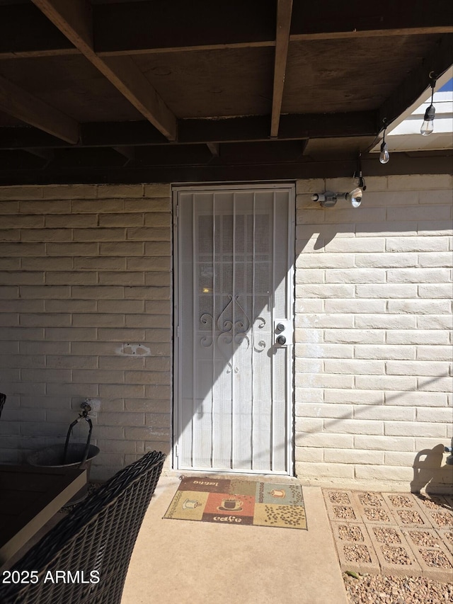 doorway to property featuring brick siding