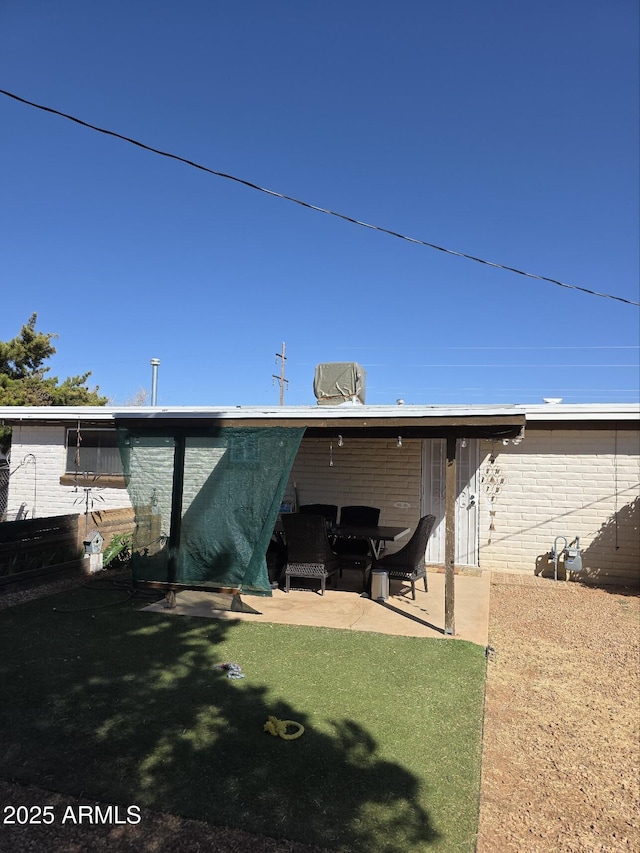 back of property featuring a patio and brick siding