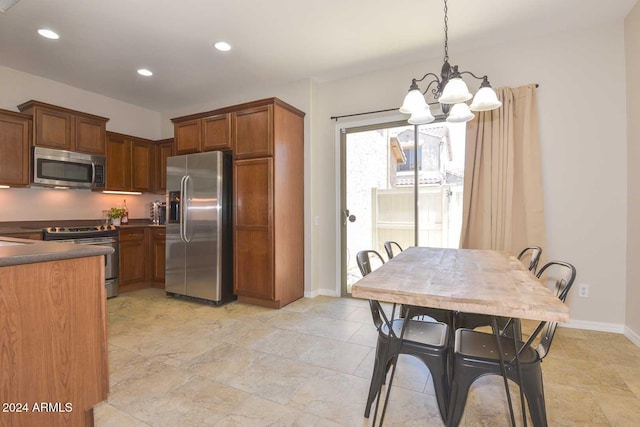 kitchen featuring stainless steel appliances, pendant lighting, and an inviting chandelier