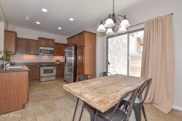 kitchen with sink, decorative light fixtures, a notable chandelier, and appliances with stainless steel finishes