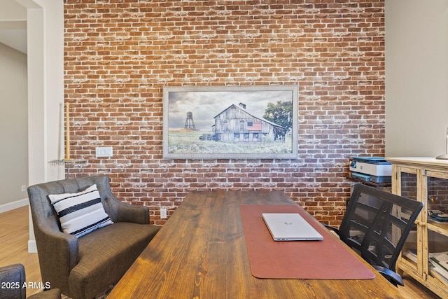 office area featuring hardwood / wood-style flooring and brick wall