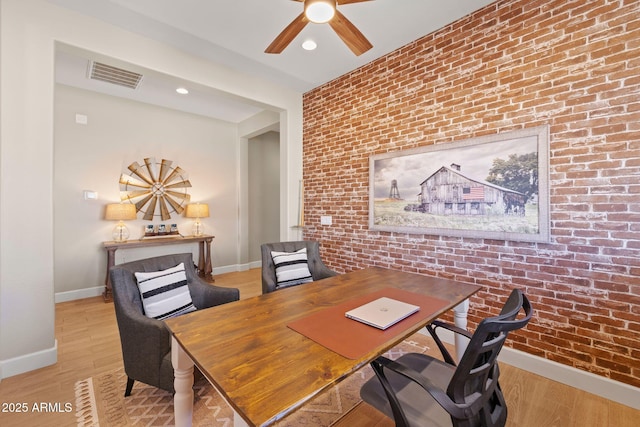 office with ceiling fan, brick wall, and light hardwood / wood-style floors