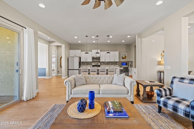 living room with ceiling fan and light wood-type flooring