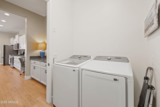 clothes washing area featuring separate washer and dryer and light wood-type flooring