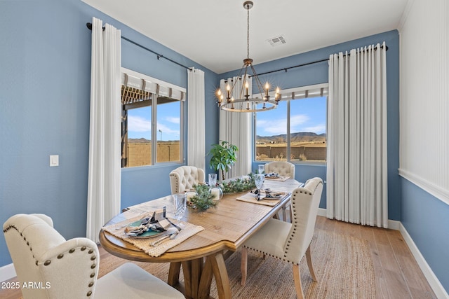 dining room featuring plenty of natural light, a chandelier, and light hardwood / wood-style flooring