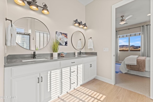 bathroom featuring hardwood / wood-style flooring, ceiling fan, and vanity