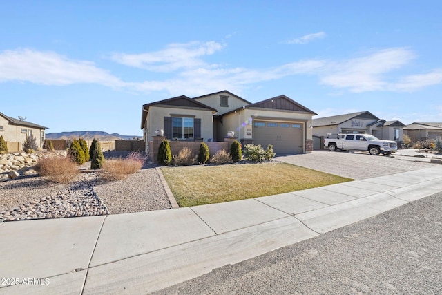 view of front of property with a mountain view, a garage, and a front lawn