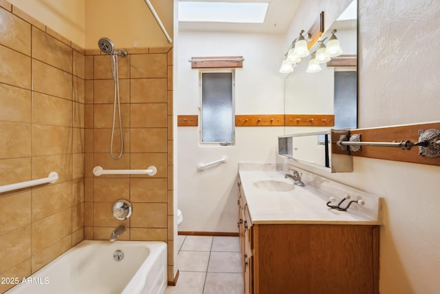 full bathroom with tile patterned flooring, toilet, a skylight, vanity, and tiled shower / bath