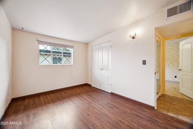 empty room with dark hardwood / wood-style flooring