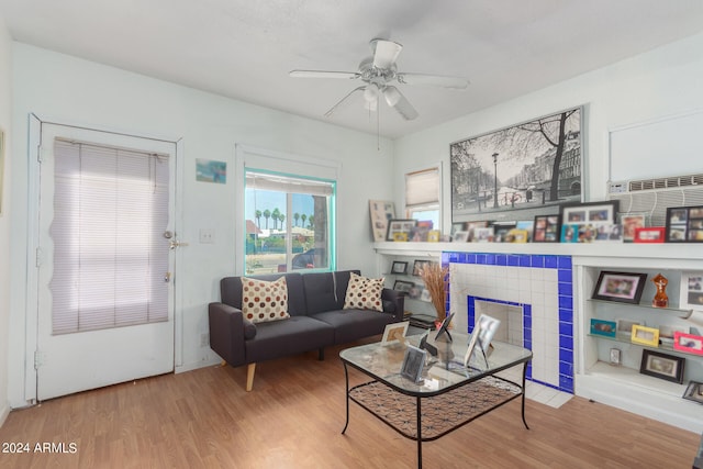 living room with light hardwood / wood-style floors, a fireplace, and ceiling fan