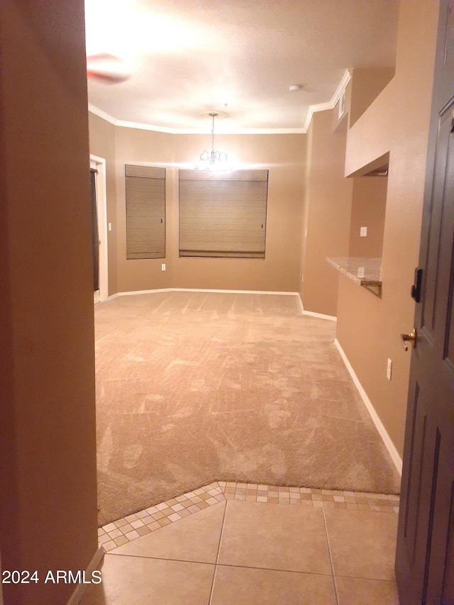 corridor with ornamental molding and light colored carpet