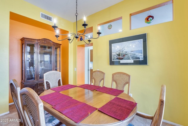 dining space featuring visible vents, a notable chandelier, and baseboards