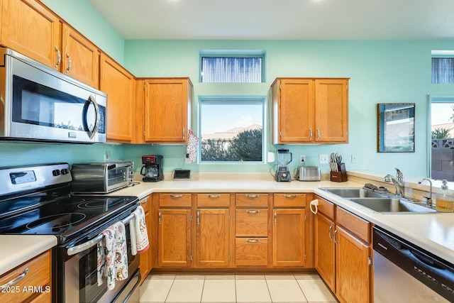 kitchen with a healthy amount of sunlight, stainless steel appliances, a sink, and light countertops