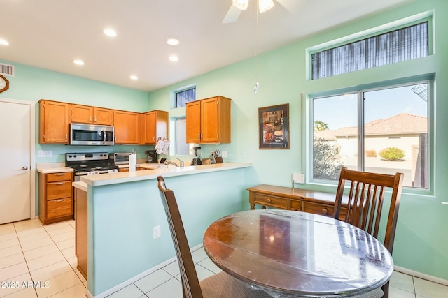 kitchen featuring recessed lighting, visible vents, light countertops, appliances with stainless steel finishes, and brown cabinets