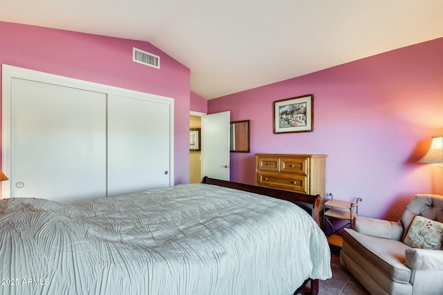 bedroom featuring visible vents, vaulted ceiling, and a closet