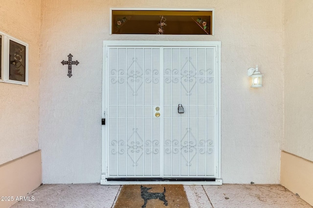 view of exterior entry with stucco siding