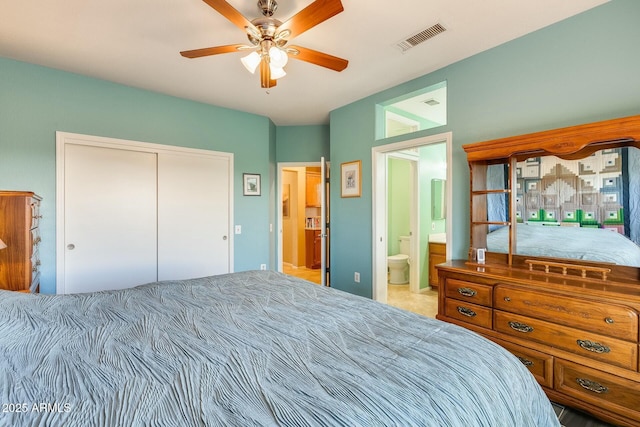 bedroom with a closet, connected bathroom, visible vents, and a ceiling fan