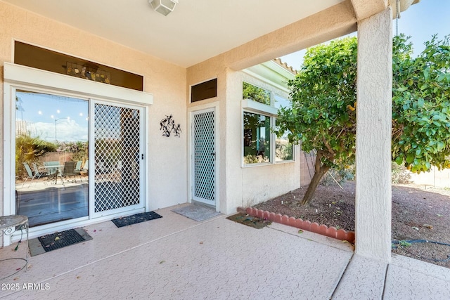 property entrance featuring visible vents, a patio, and stucco siding