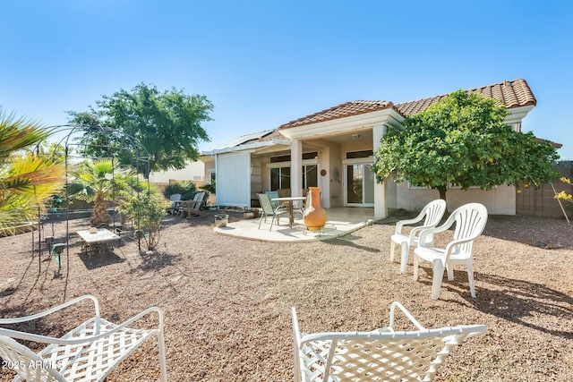 rear view of property with a patio area, fence, stucco siding, and a tiled roof