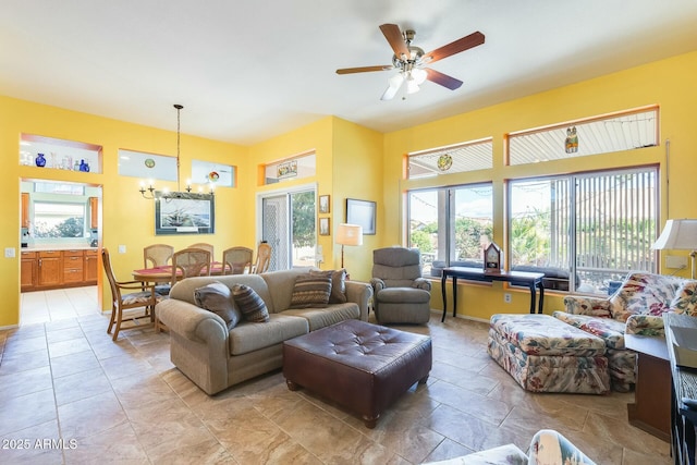 living area featuring ceiling fan with notable chandelier