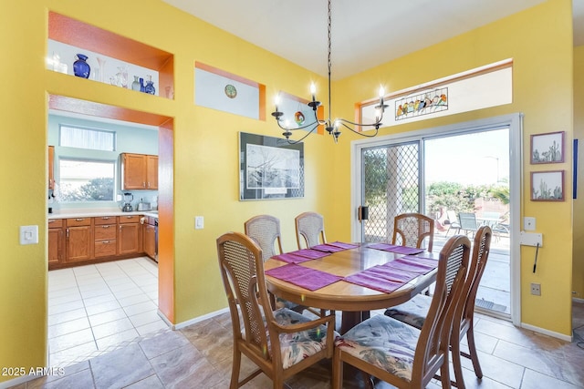 dining space featuring baseboards, a wealth of natural light, and a notable chandelier