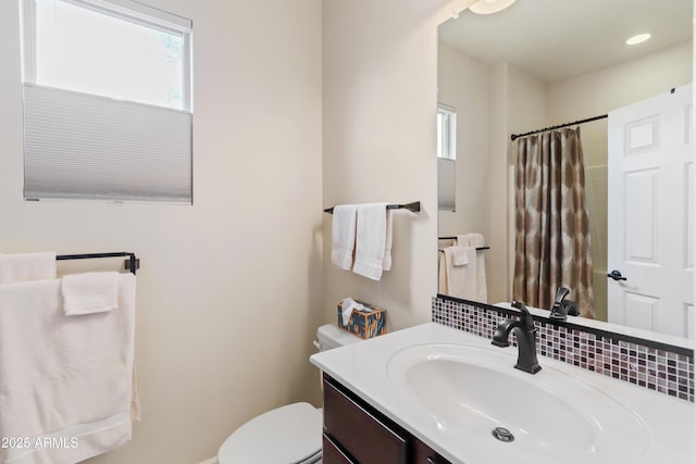 full bath featuring a shower with curtain, toilet, and vanity