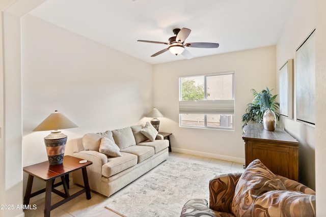 living area featuring tile patterned floors, baseboards, and a ceiling fan