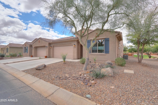 view of front of house with central air condition unit, stucco siding, driveway, an attached garage, and a tiled roof