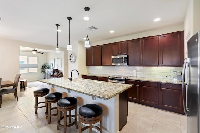 kitchen featuring tasteful backsplash, visible vents, appliances with stainless steel finishes, hanging light fixtures, and a sink