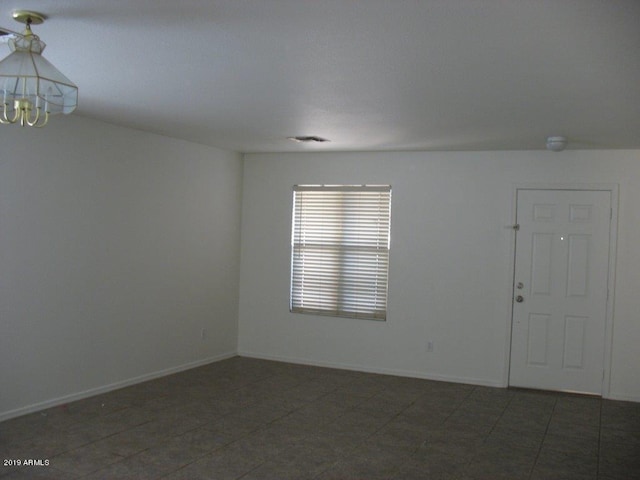 empty room featuring a chandelier