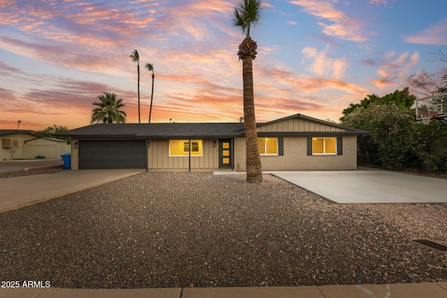 1911 E Lawrence Rd, Phoenix, AZ 85016 - view of front of home featuring board and batten siding, concrete driveway, and an attached garage