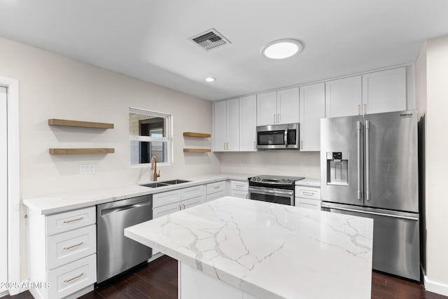 1911 E Lawrence Rd, Phoenix, AZ 85016 - kitchen with stainless steel appliances, open shelves, light stone counters, a center island, and dark wood finished floors