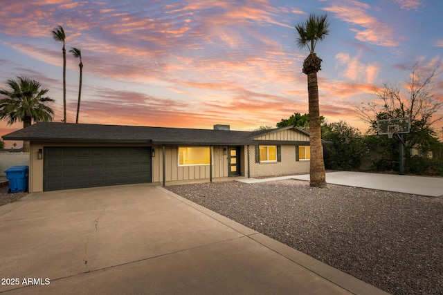 1911 E Lawrence Rd, Phoenix, AZ 85016 - view of front of property featuring driveway, an attached garage, and board and batten siding