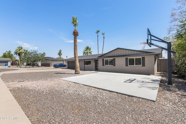 1911 E Lawrence Rd, Phoenix, AZ 85016 - back of property featuring board and batten siding, driveway, brick siding, and an attached garage