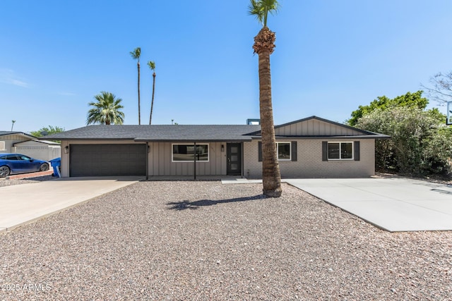 1911 E Lawrence Rd, Phoenix, AZ 85016 - ranch-style house with board and batten siding, concrete driveway, a garage, and brick siding