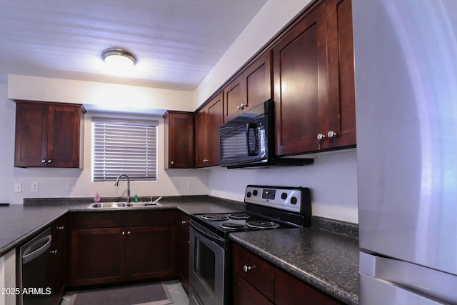 kitchen featuring dark countertops, dark brown cabinetry, appliances with stainless steel finishes, and a sink