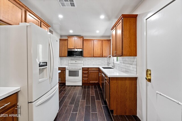 5709 N 16th St, Phoenix, AZ 85016 - kitchen with white appliances, wood finish floors, brown cabinetry, visible vents, and a sink