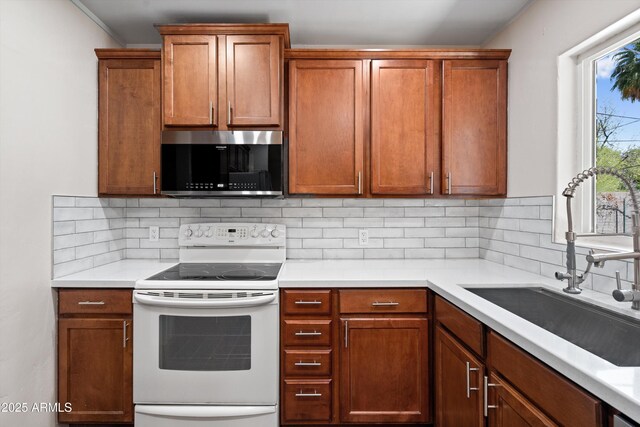 5709 N 16th St, Phoenix, AZ 85016 - kitchen featuring stainless steel microwave, light countertops, electric range, backsplash, and a sink