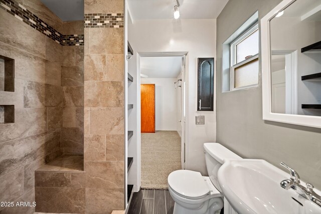 5709 N 16th St, Phoenix, AZ 85016 - full bathroom featuring toilet, tiled shower, wood finished floors, and a sink