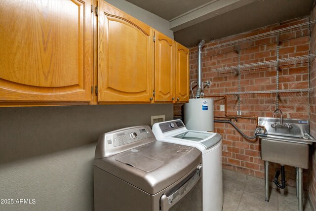 5709 N 16th St, Phoenix, AZ 85016 - laundry room with separate washer and dryer, tile patterned flooring, water heater, brick wall, and cabinet space