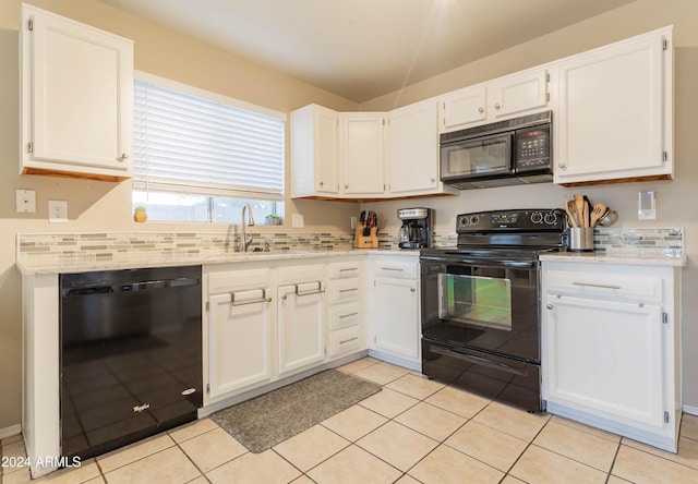 kitchen with black appliances, light tile patterned floors, light stone counters, and white cabinets