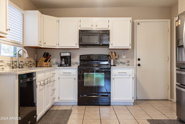 kitchen featuring white cabinetry, light tile patterned floors, black appliances, light stone counters, and sink